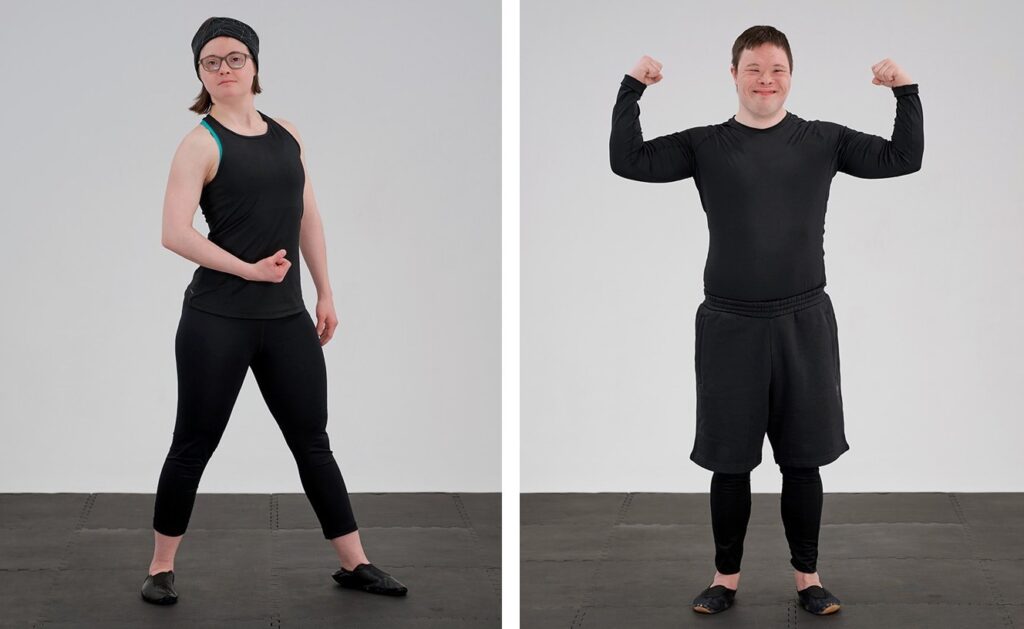 Sol (links) und Jannic (rechts) zeigen ihre Muskeln. Dabei sind sie in schwarzer Sportkleidung vor hellgrauem Hintergrund zu sehen.